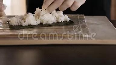 <strong>寿司</strong>师傅的特写在诺里铺饭。 <strong>寿司制作</strong>工艺。 厨师`的手。 竹垫